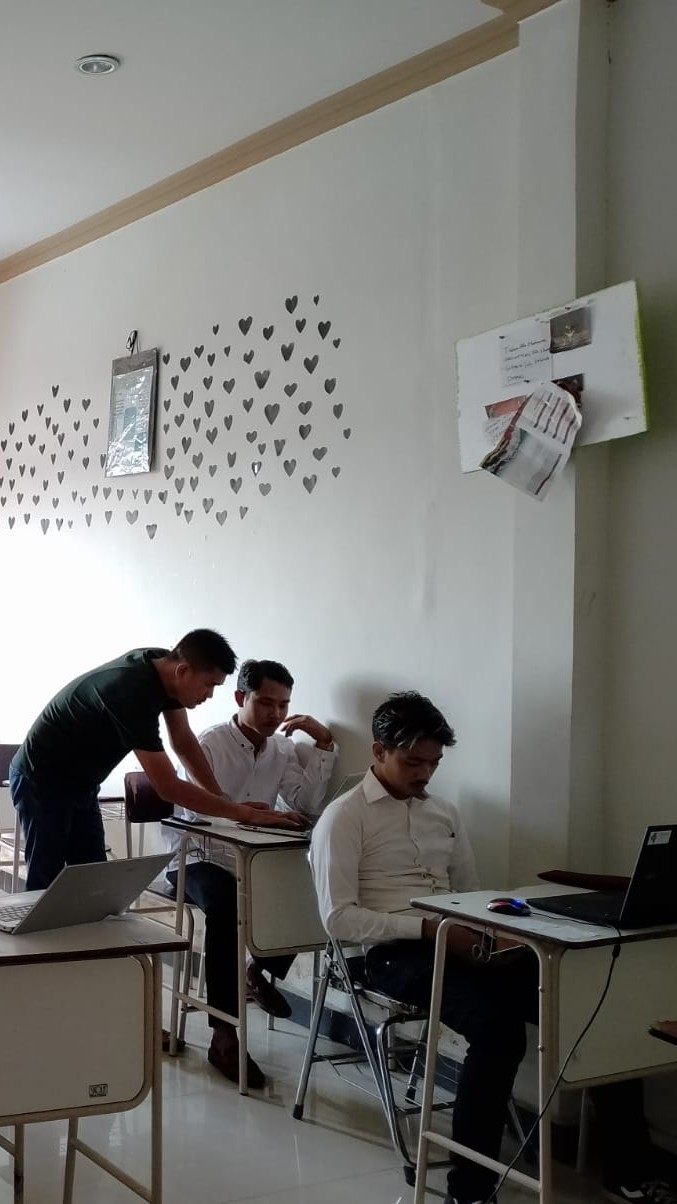 Tutor mendampingi peserta yang belajar menggunakan laptop